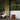 Modern outdoor patio with wicker chair, hanging light, portable glass light and side table.