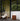 Modern outdoor patio with wicker chair, hanging light, portable glass light and side table.