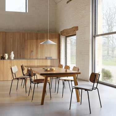Modern dining area with Carl Hansen wooden table and chairs in a bright room.