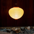 Round tripod akari 10A washi paper paper lantern on a stand with a dark background