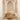 Wooden chair on a textured rug in a room with high arched ceilings and white walls.