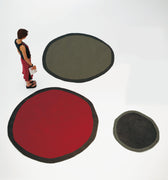 three round rugs in different colors on a white background