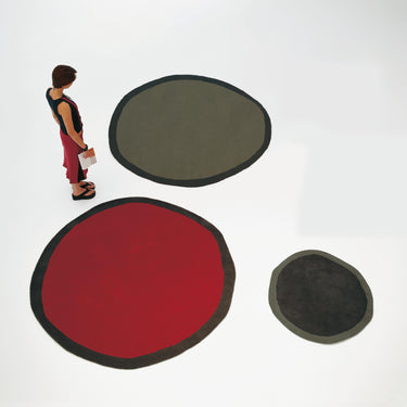 three round rugs in different colors on a white background