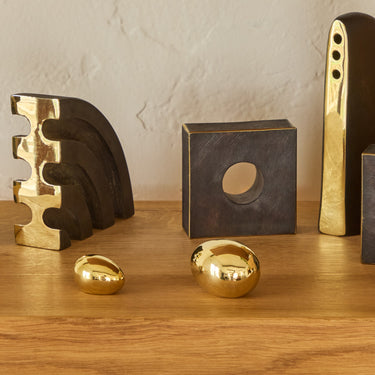 aubock egg brass paperweights on an oak chapo bookshelf