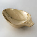 brass ashtray or catchall on a light gray background