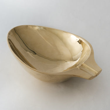 brass ashtray or catchall on a light gray background
