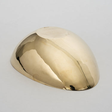 Polished gold object on a light gray background