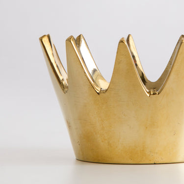 Gold crown-shaped object on a white background