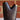 Dark brass vase with gold accents on a white surface with a brick wall background