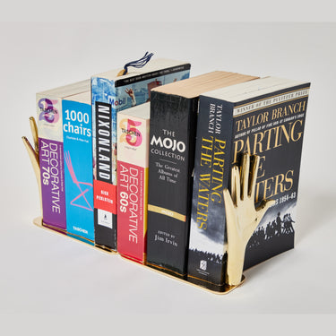 Bookend shaped like a hand holding books on a white background