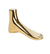 Brass aubock foot-shaped paperweight aubock on a white background