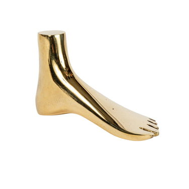 Brass aubock foot-shaped paperweight aubock on a white background