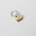 Gold heart-shaped pendant on a light gray background