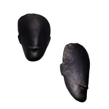Two black brass toscanini head sculptures on a white background