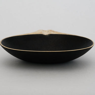 Black ceramic bowl on a light gray background