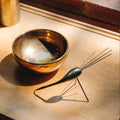 Decorative bowl and whisk on a wooden surface with warm lighting