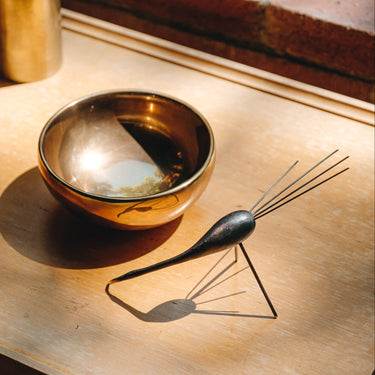 Decorative bowl and whisk on a wooden surface with warm lighting