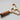 Gold and wooden tool on a light gray background