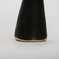 detail of cone-shaped brass bookend on a light gray background