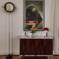 Wooden cabinet with marble top in a room with a poster on the wall.