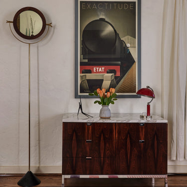 Wooden cabinet with marble top in a room with a poster on the wall.