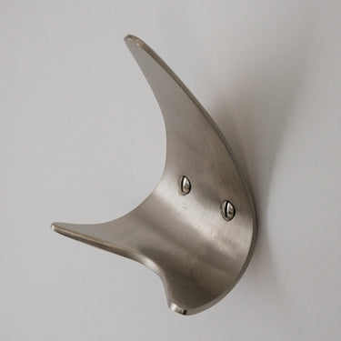 brushed nickel wall hook on a plain background