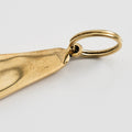 Gold foot-shaped pendant on a light gray background