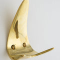 Gold brass wall hook on a white background