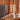 Wooden basket on a wooden shelf with a gray cushioned chair in the background.