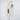 Wall-mounted light fixture with gold finish and white glass shade on a light gray background