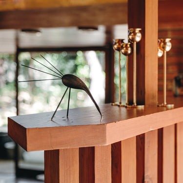 Metal sculpture on a wooden surface with blurred background