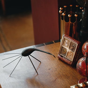 Decorative items including a model of a spider and a small box on a wooden surface.