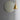 Round mirror with gold frame and pendant light on a gray wall in entryway