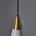 Close-up of a pendant light with a brass cone-shaped fixture against a gray background