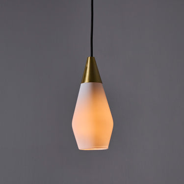 Two glass pendant lights similar to tynell or mauri almari with brass accents on a grey background