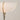 Modern floor lamp with a white shade and gold base on a plain background