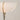 Modern floor lamp with a white shade and gold base on a plain background