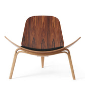 hans wegner shell chair with a black cushion on a white background