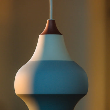 Modern cirque ceramic pendant light with a white and blue design against a blurred background