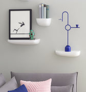 Gray sofa with colorful cushions against a light gray wall with vitra shelves and decor