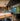 Modern restaurant interior with wooden tables, black chairs, and pendant lights by Moss Objects Germany