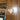 Wooden wall with a decorative light fixture and books on a shelf.