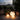 Glowing spherical lights on a balcony with plants and a cityscape view.
