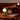 Dining area with tables, chairs, and decorative lamps in a warm setting.