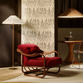 Red armchair in a room with patterned screen and tynell lamps