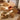 Two wicker chairs and a small table on a wooden floor with a rug.