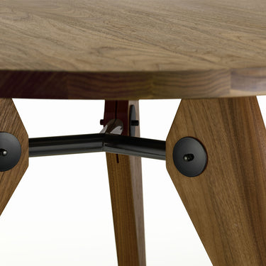 walnut prouvé gueridon table detail with metal legs on a white background