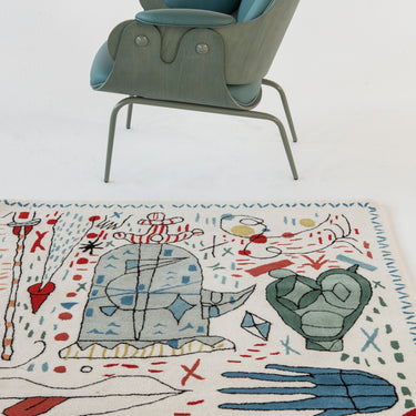 Decorative rug with abstract designs on a white floor with a chair.