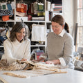 two designers with textiles in a studio