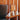 Wooden table with a bentwood midcentury table lamp  against a wooden paneled wall.